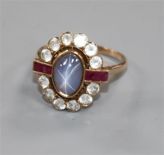 A yellow metal, cabochon star sapphire, ruby and white stone oval cluster ring, size P/Q.